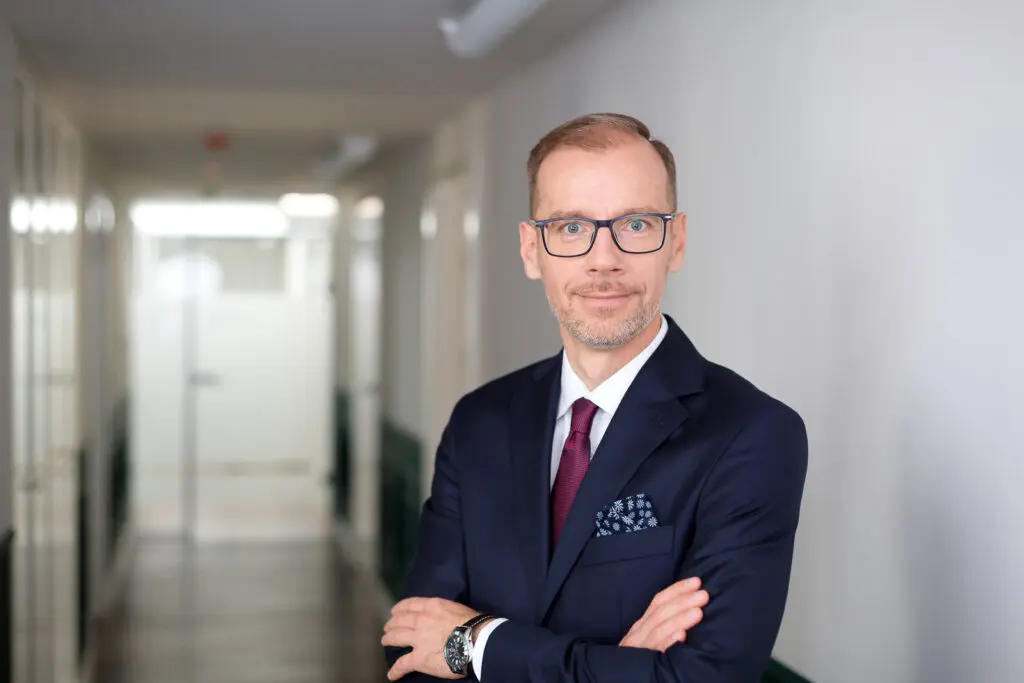 Na zdjęciu widoczny Maciej Barszczewski, Członek Zarządu, CERES Dom Inwestycyjny. W tle korytarz w biurze.